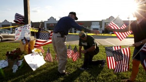 Mourners places flags at a growing memorial in front of the Armed Forces Career Center in Chattanooga, Tennessee on July 16, 2015. Four Marines were killed on Thursday by a gunman who opened fire at two military offices in Chattanooga, Tennessee, before being fatally shot himself in an attack officials called a brazen, brutal act of domestic terrorism.  Credit: Tami Chappell/Reuters